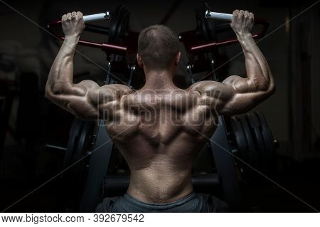 Bodybuilder Handsome Strong Athletic Rough Man Pumping Up Back Muscles Workout Fitness And Bodybuild