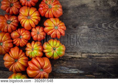Red Ribbed Tomatoes On A Wooden Background. American Or Florentine Variety Nina. Food On The Table T