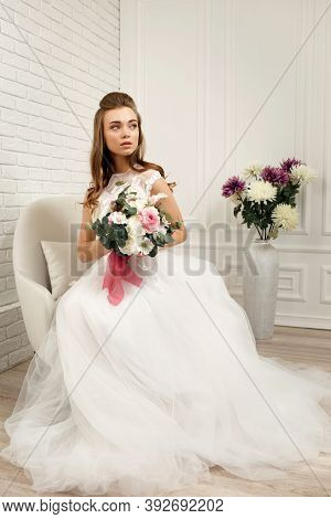 Gorgeous Beautiful Young Bride In A Luxurious Wedding Dress With Flower Bouquet In White Studio Inte