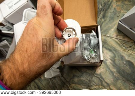 Man Hand Unboxing Package Of Internet Connected Thermostatic Valve Connected Iot Device To The Gas H