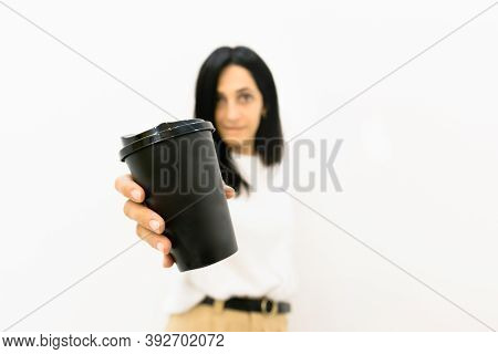 Woman In The Background Holds Black Disposable Coffee Paper Cup With Face Expression Isolated In Whi