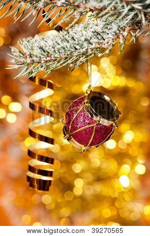 tamburo di Natale sul ramo di un albero d'abete e fondo oro