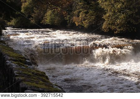 River White Water And Waterfall With Trees And Moss Covered Stone Wall