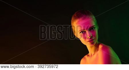 Mavelous. Portrait Of Fashion Model In Neon Light On Dark Studio Background. Beautiful Caucasian Wom