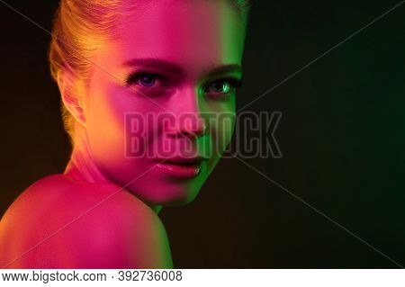 Mavelous. Portrait Of Female Fashion Model In Neon Light On Dark Studio Background. Beautiful Caucas