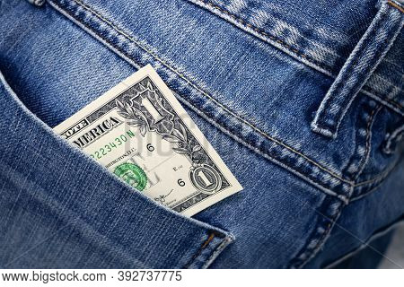One Dollar Bill In The Back Pocket Of Jeans. One Buck In A Denim Pocket.