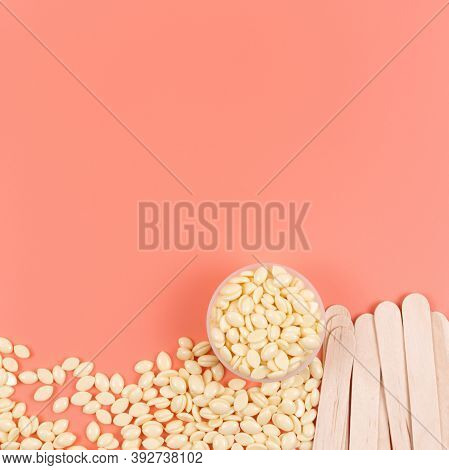 Cosmetology Background. Hot Wax In Granules And Wooden Depilatory Spatulas On Pink Backdrop. Top Vie