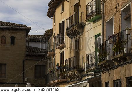 Ayerbe, Spain - October 15, 2020: Picturesque Balconies, Facades And Houses In Plaza Of Ramon Y Caja