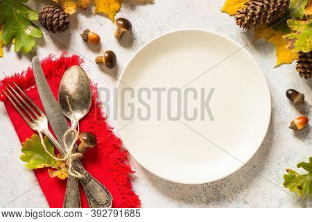 Thanksgiving Food Concept. Autumn Table Setting With Craft Plate, Silverware And Fall Decorations At