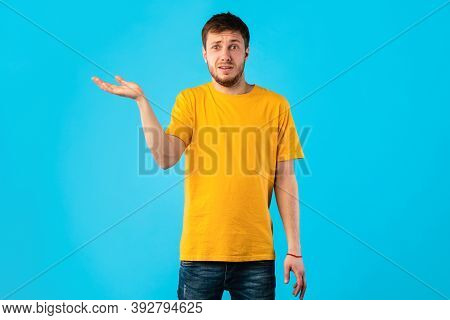 Who Knows. Portrait Of Funny Confused Man Shrugging Shoulders With Tipping Hand, Looking At Camera P