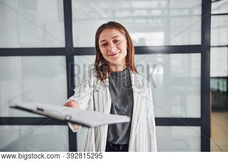 Portrait Of Young Woman In White Formal Clothes That Standing Indoors.