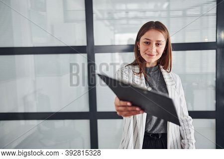 Portrait Of Young Woman In White Formal Clothes That Standing Indoors.