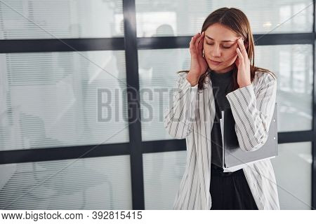 Portrait Of Young Woman In White Formal Clothes That Standing Indoors.