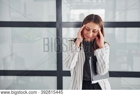 Portrait Of Young Woman In White Formal Clothes That Standing Indoors.