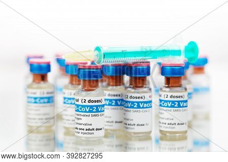 Bottles Of New Sars-cov-2 Vaccine On Table With Plastic Syringe