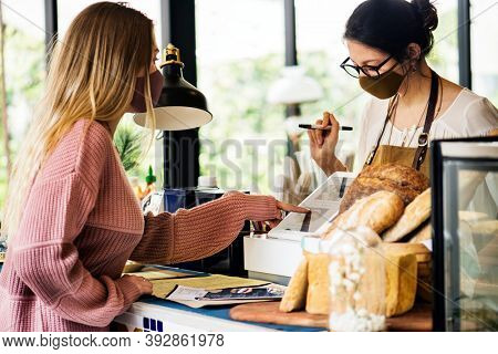 Woman wearing mask ordering food in a cafe restaurant covid 19