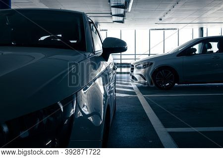 Underground parking. Cars parked in a garage with no people. Many cars in parking garage interior. Underground parking with cars (color toned image)