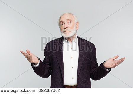 Confused Senior Man Showing Dubium Gesture While Looking At Camera Isolated On Grey
