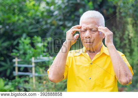 Senior Man With A Headache, Feeling Pain, And With An Expression Of Being Unwell While Standing In T
