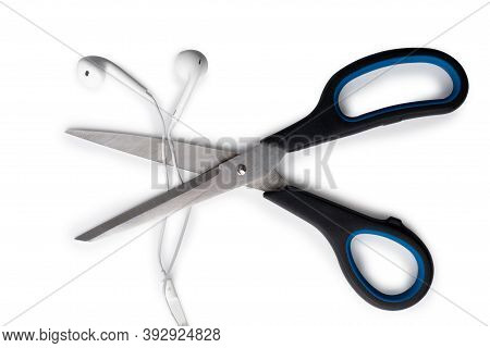 Conceptual Photo Of Cut Off The Earphones Wire. Bluetooth Headphones Are A New Trend. Wireless Techn
