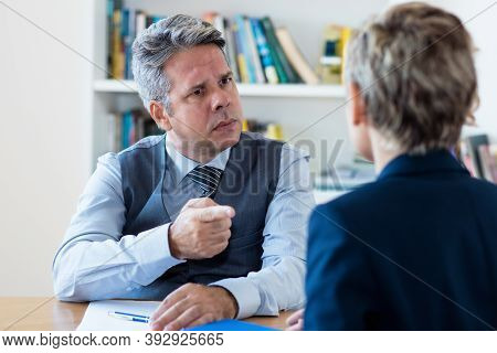 Angry Mature Businessman Firing Employee At Office