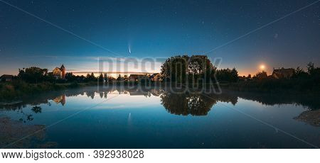 Dobrush, Belarus. Comet Neowise C2020f3 Anf Rising Moon In Night Starry Sky Reflected In Small Lake 