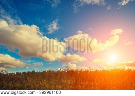 Sinrise Over The Field With Cloudy Sky