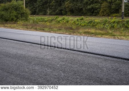 A Large Layer Of Fresh Hot Asphalt. Layer Of Asphalt Raw Material In A Shallow Depth Of Field. Rolle