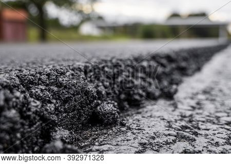 A Large Layer Of Fresh Hot Asphalt. Layer Of Asphalt Raw Material In A Shallow Depth Of Field. Rolle