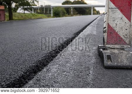 A Large Layer Of Fresh Hot Asphalt. Layer Of Asphalt Raw Material In A Shallow Depth Of Field. Rolle