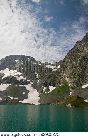 View Of The Imereti Lake And Mountains. Blue Lake Surrounded By Mountains And Glaciers.