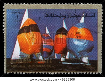 AJMAN - ca 1973: en stämpel som skrivs ut i Ajman visar segling, sommarspelen, ca 1973