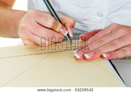 a woman signs a contract or a will with a fountain pen.
