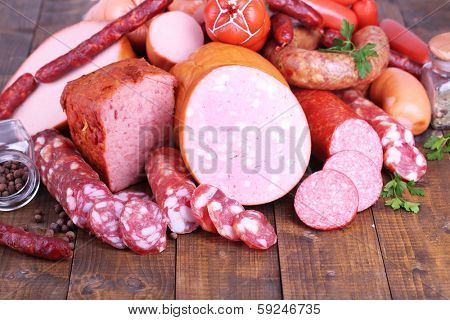Lot of different sausages on wooden table close-up