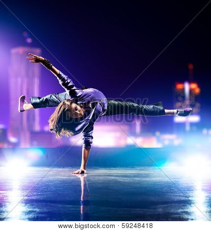 Young woman dancing on city background.