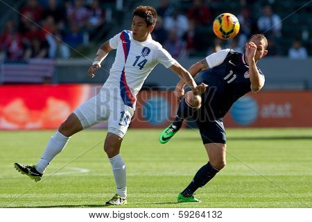 CARSON, CA. - FEB 01: Korea D Yong Lee #14 & USA M Brad Davis #11 during the U.S. mens national team soccer friendly against Korea Republic on Feb 1st 2014 at the StubHub Center in Carson, Ca.