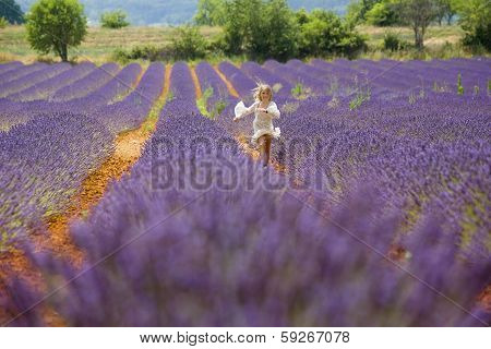 Young girl runs and jumps in a purple field of lavender