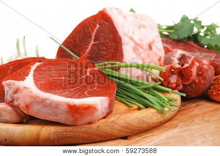raw meat : fresh beef pork big rib and fillet with garlic and green stuff on wood isolated over white background