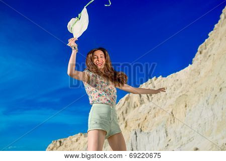 Young Happy Woman Jumping On The Sandy And Sky Background