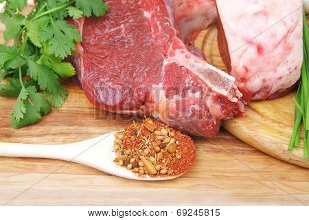 raw meat : fresh beef pork big rib and fillet with garlic and green stuff on wood isolated over white background