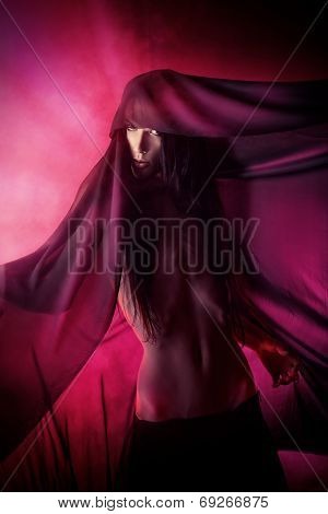 Art photo of a beautiful graceful brunet man dancing with airy black chiffon. Fashion.