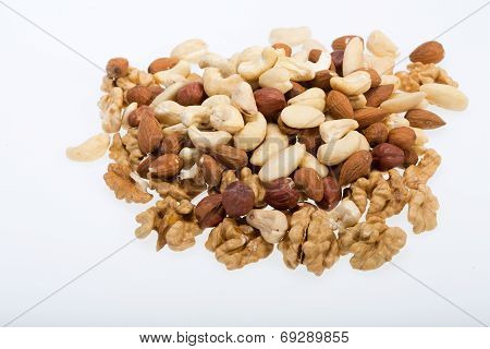 mixed nuts - hazelnuts walnuts cashews pine nuts isolated on white background