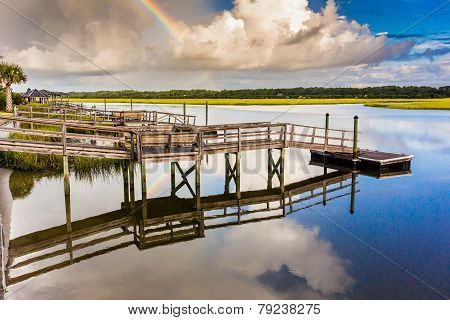 Rainbow And Docks Reflecting In Water