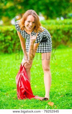 Impish Girl Posing On The Grass In The Park
