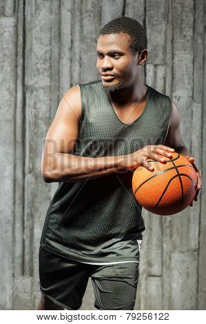 Afro-american male basketball player holding ball