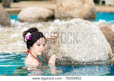 Attractive Woman With Flower In Long Hair On Tropical Beach Sunbathing. Sea Background
