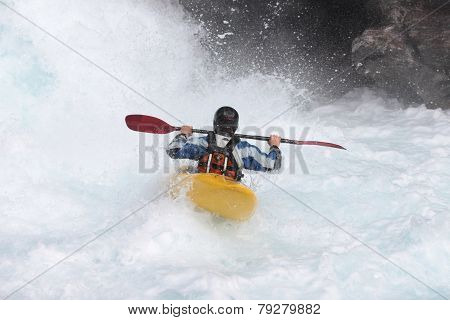 A man in kayak in Norwegian river. View from the back.