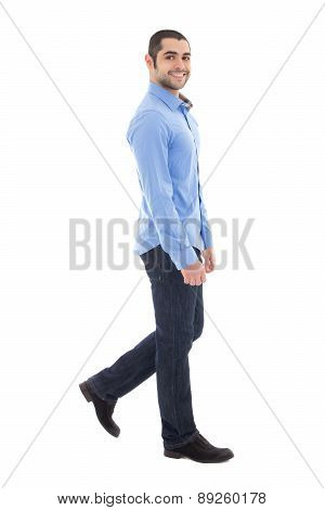 Side View Of Young Arabic Bearded Business Man In Blue Shirt Walking Isolated On White