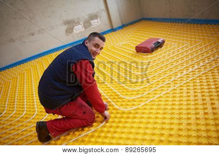group of workers installing underfloor heating and colling in modern home