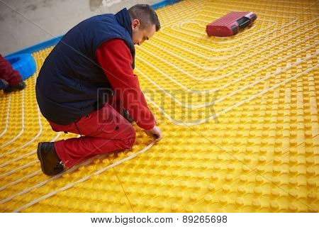 group of workers installing underfloor heating and colling in modern home